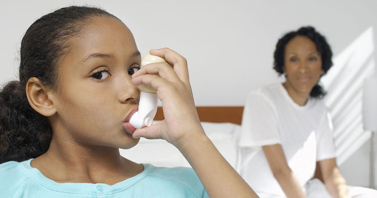 a young girl breathing in her inhaler