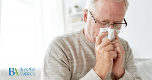 a man sneezing into a handkerchief