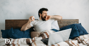 a man yawning in bed