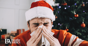 a man sneezing wearing a santa hat